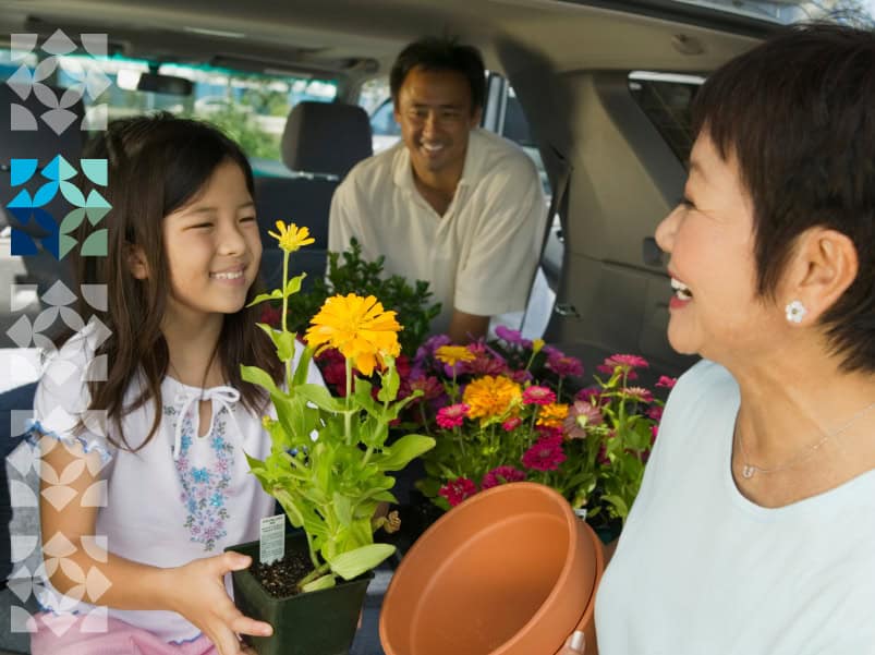 family in car holding plants