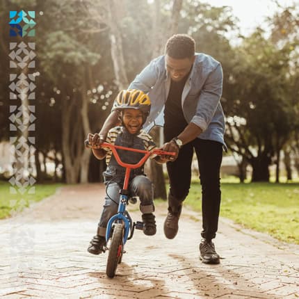 parent teaching child how to ride a bike